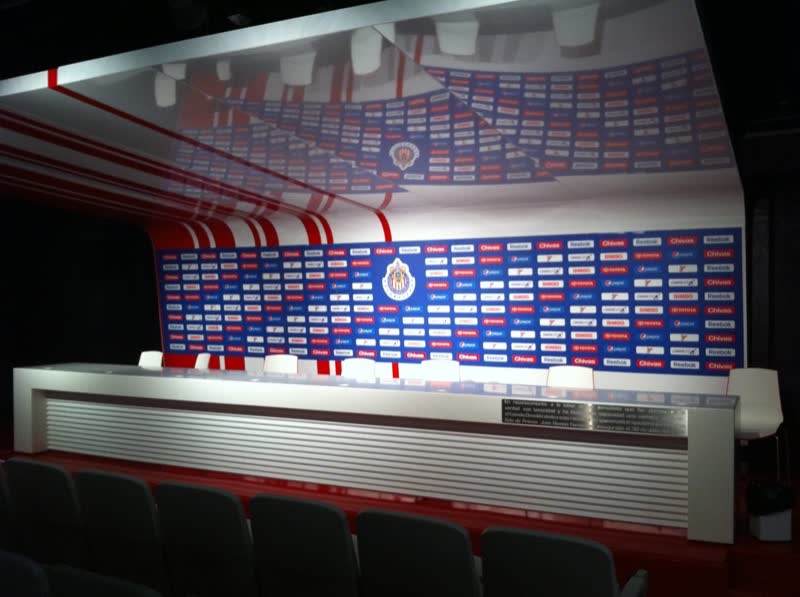 Sala de prensa con mesa y mampara