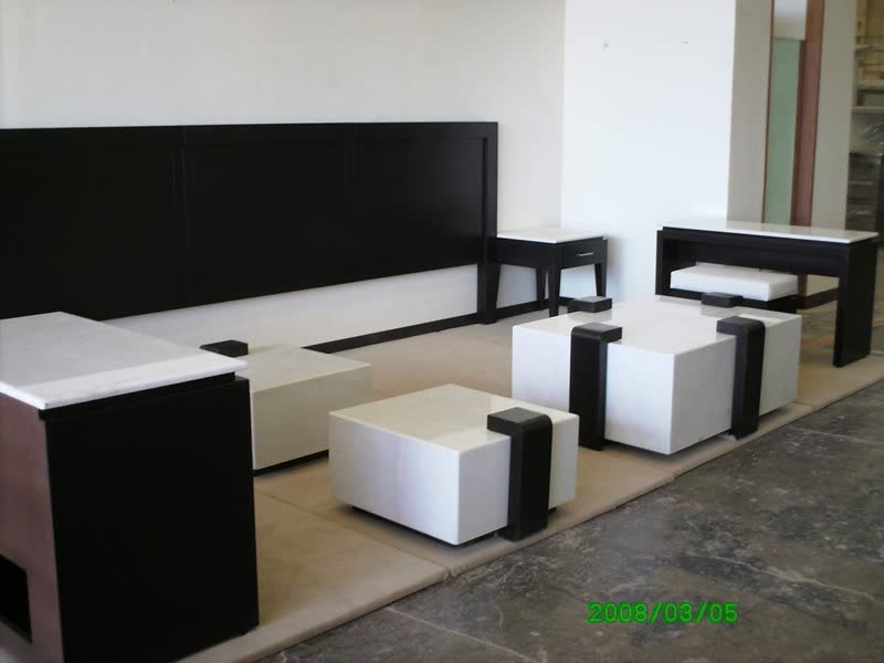 Lounge con cabecera negra y taburetes blancos