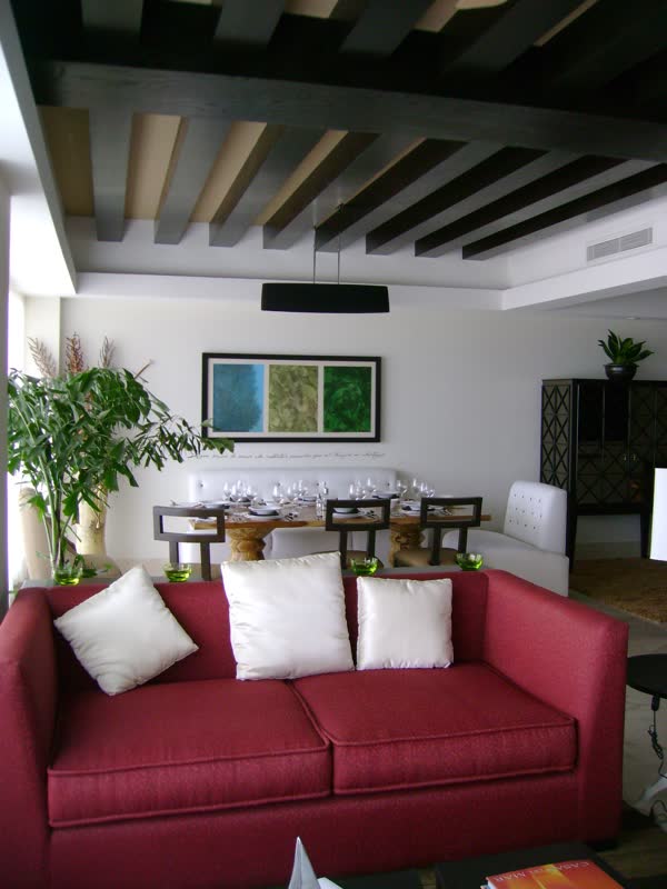 Sala con sofá rojo bajo vigas de madera