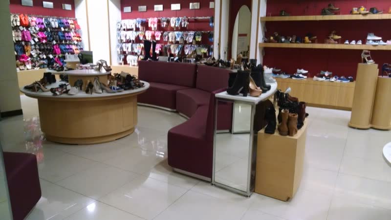 Exhibidores y sillón curvo en una zapatería
